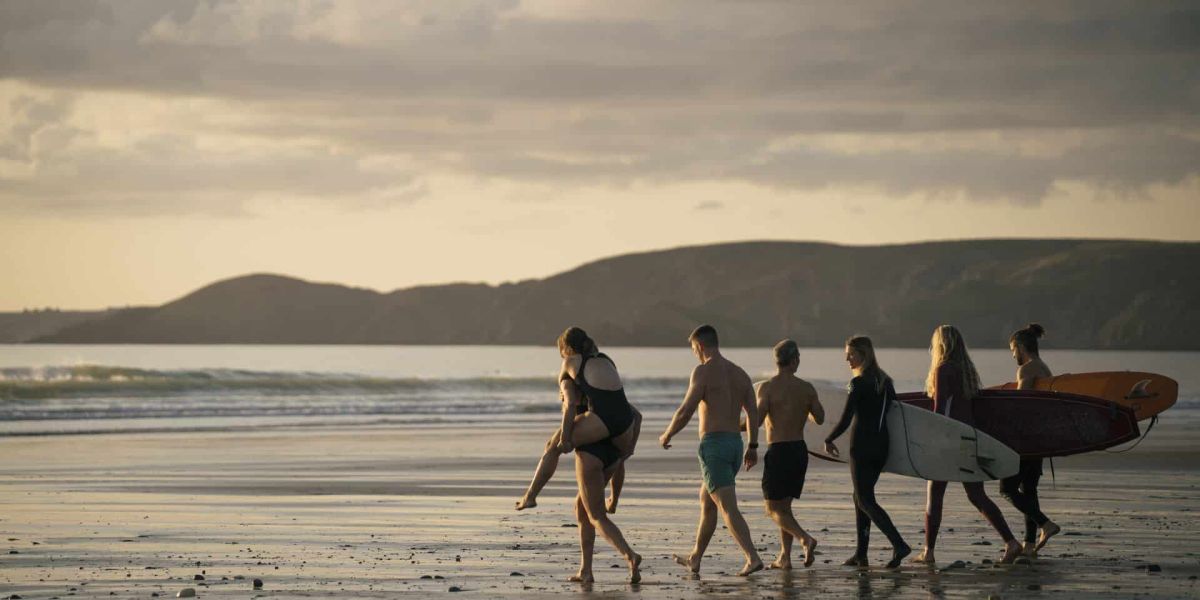 wales urlaub wyldmag outdoormagazin beitragsbild mit surfern am strand