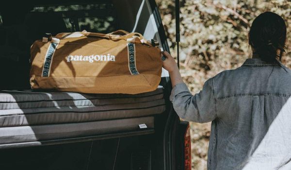 Patagonia Black Hole Duffel 55 Test Frau am Kofferraum