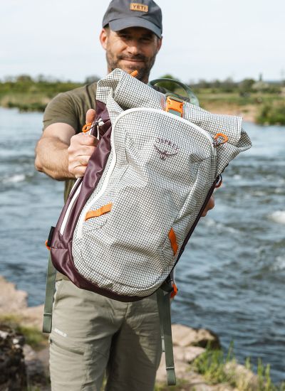 gewinnspiel osprey transpoter roll top rucksack wird von model gehalten
