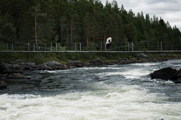 Frau läuft über Hängebrücke in Schweden